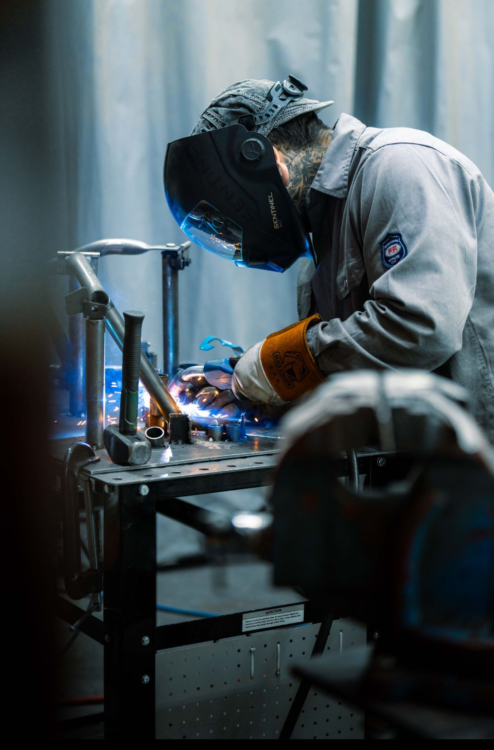 Person welding metal components in a workshop setting